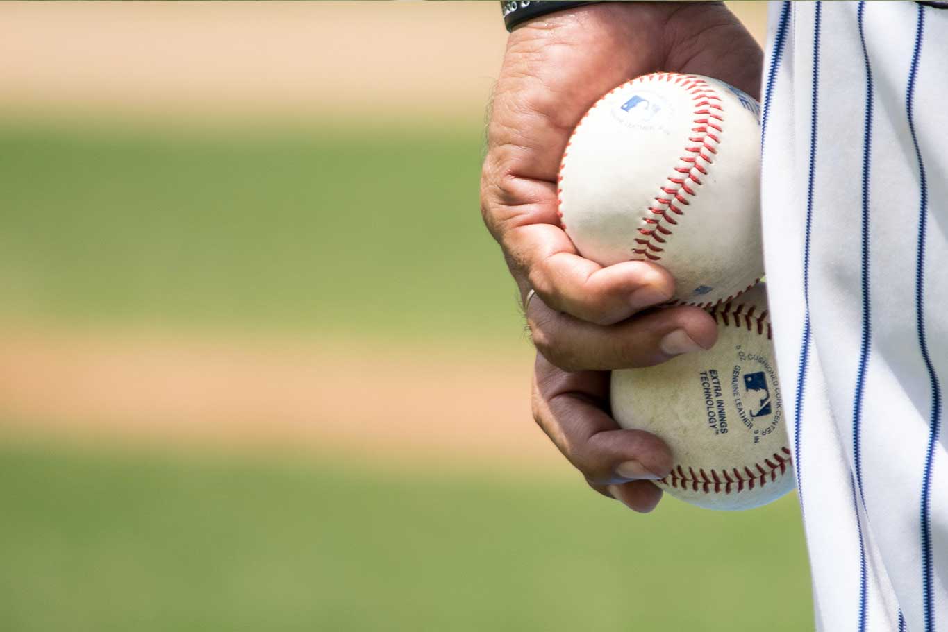 Baseball pitcher holding two baseballs